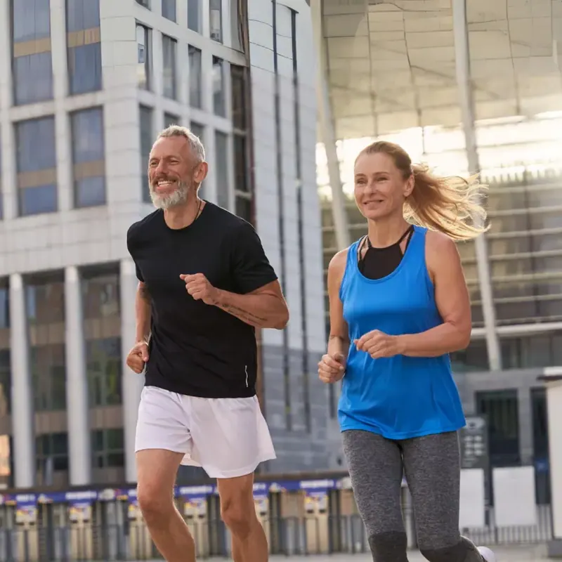 A couple running outdoors, representing renewed energy from hormone therapy