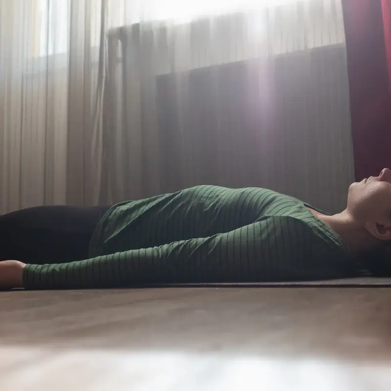 A woman lying at rest during a KLOUD PEMA relaxation session