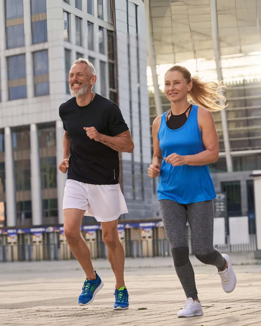 A couple running outdoors, representing renewed energy from hormone therapy