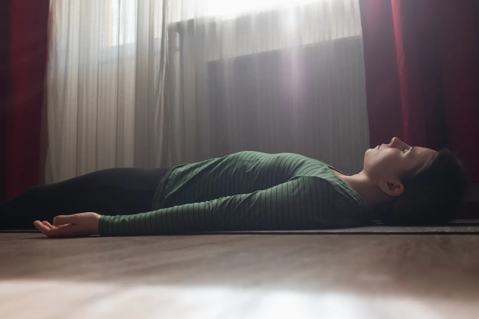 A woman lying at rest during a KLOUD PEMA relaxation session